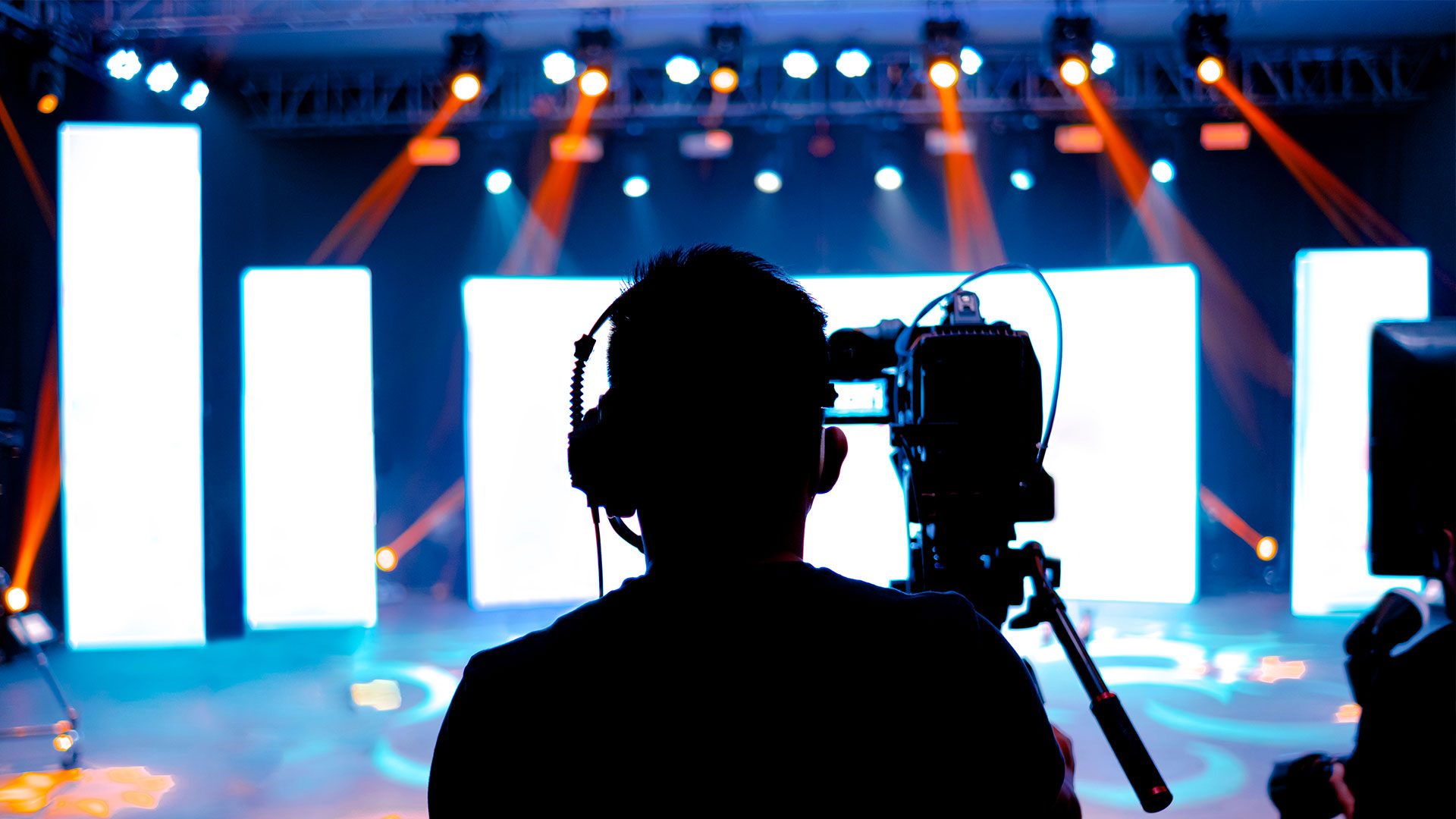 A person captures a concert on video, ensuring smooth visuals for live broadcasting with precision and reliability.